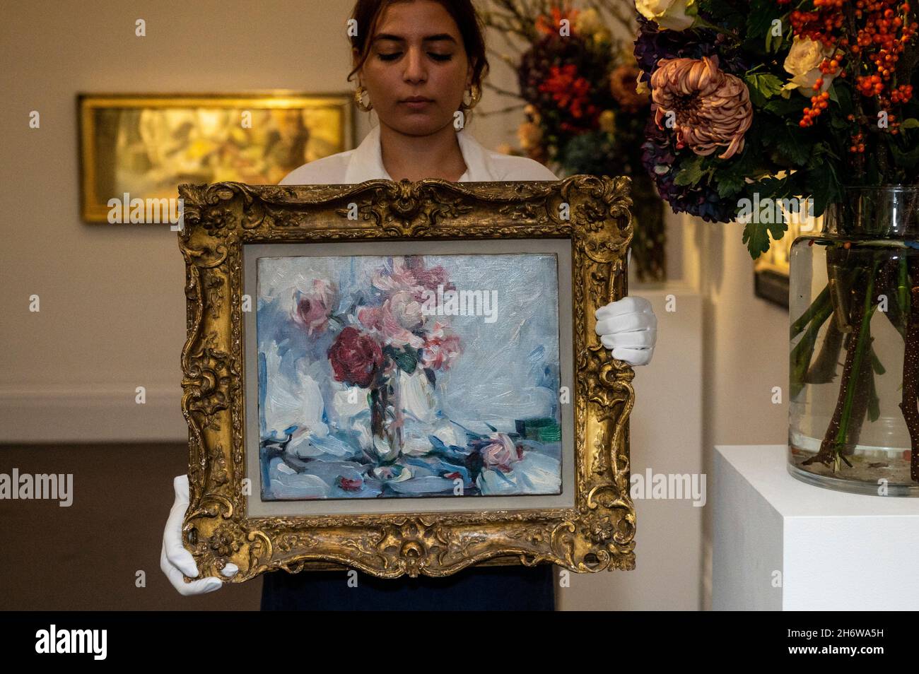 Londres, Royaume-Uni.18 novembre 2021.Un technicien présente 'la vie de Still de roses roses et rouges dans un vase', vers 1906, par Samuel John Paploe (est.£150,000-250,000) à l'avant-première de la prochaine vente d'art moderne britannique et irlandais à Sotheby's New Bond Street.Credit: Stephen Chung / Alamy Live News Banque D'Images