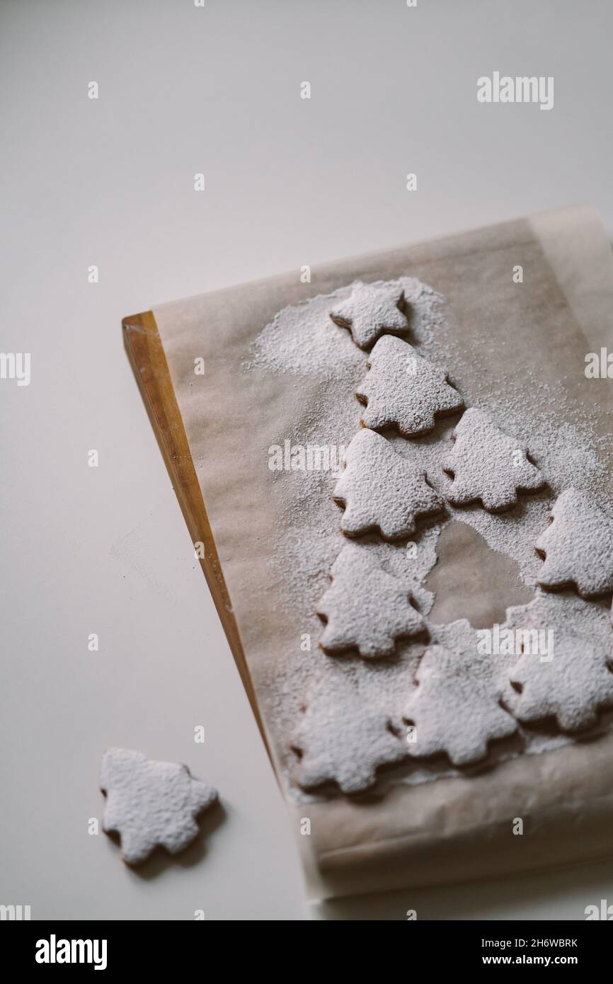 Arbre de Noël en pain d'épice parsemé de sucre en poudre sur parchemin.Concept créatif de Noël et du nouvel an, minimalisme, gros plan, plat, ,w Banque D'Images