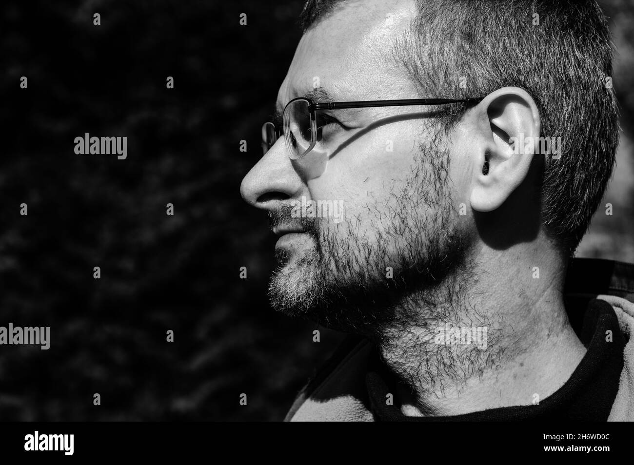 Portrait de profil noir et blanc gros plan d'un homme d'âge moyen en lunettes Banque D'Images