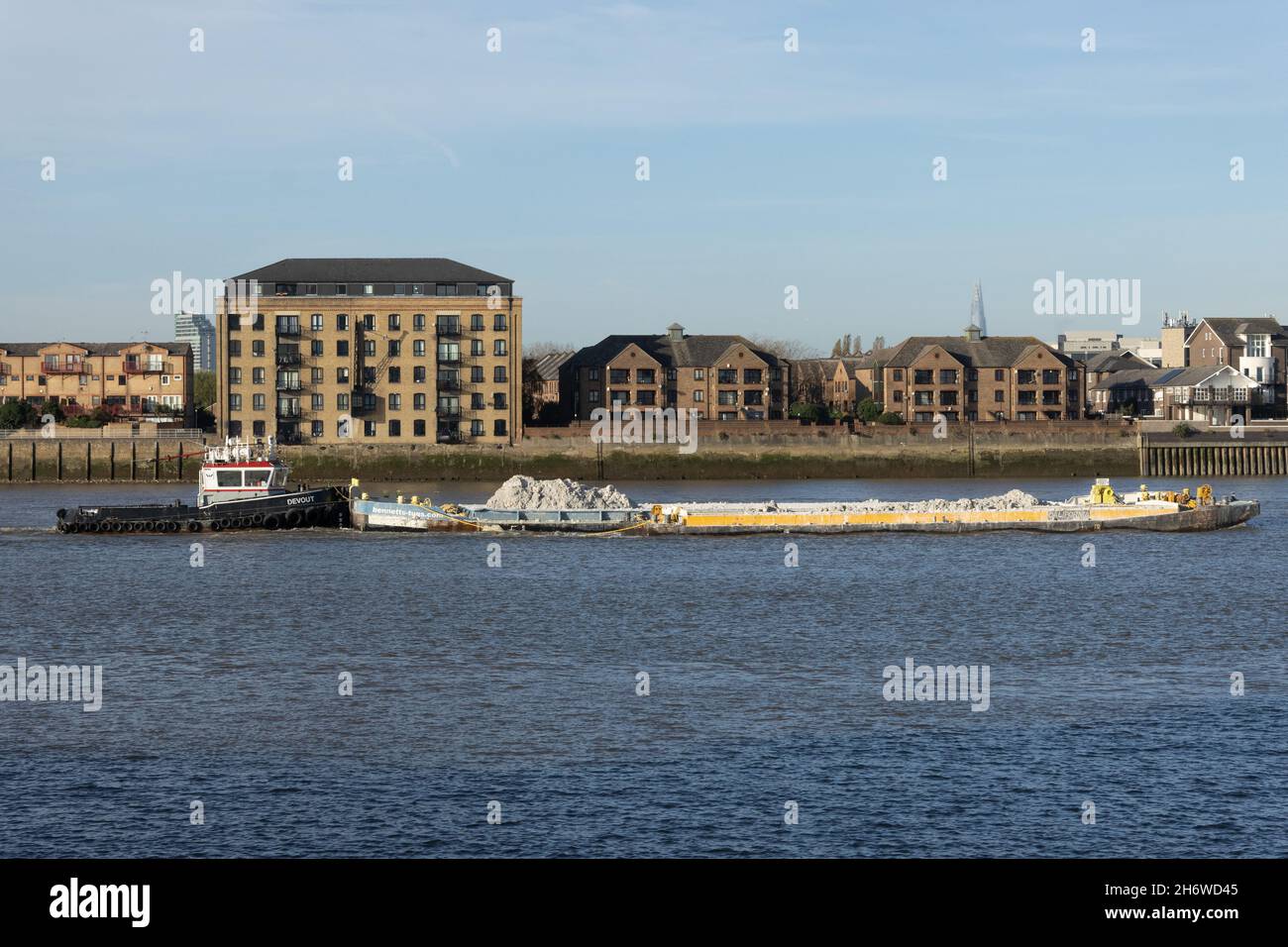 Remorqueur poussant une barge pleine de décombres le long de la Tamise, Londres UK Tug poussant une barge pleine de décombres le long de la Tamise, Greenwich, Londres UK Banque D'Images