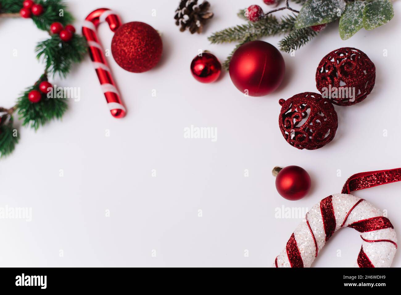 Photo de Noël des branches d'un arbre avec des jouets rouges et des boules sur fond blanc. Banque D'Images