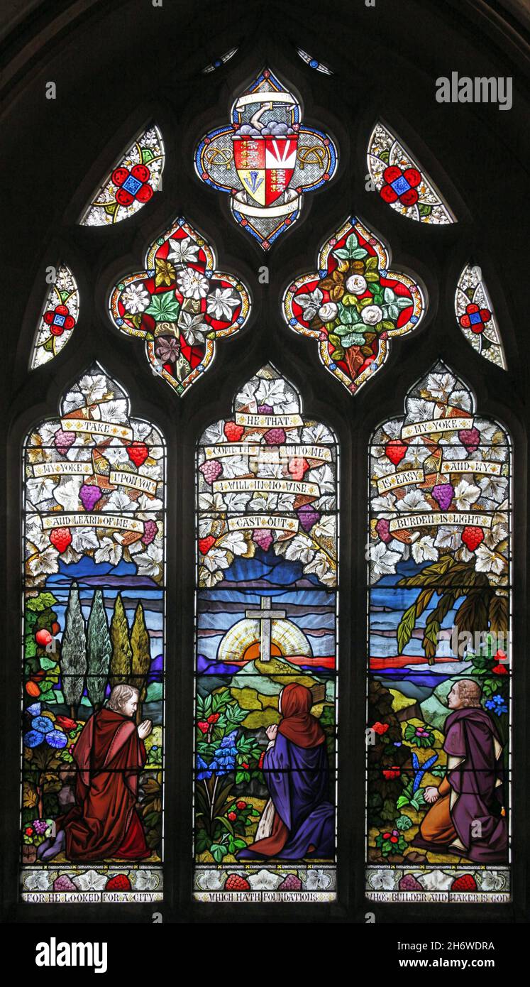 Une fenêtre en vitraux d'Alexander Gibbs (1865) représentant des figures à genoux devant la croix, Église de la Sainte-Trinité, Blatherwycke, Northamptonshire Banque D'Images