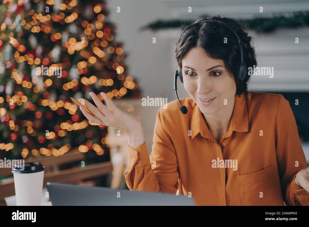 Une femme consultante CallCenter dans le micro-casque/oreillette discutant avec le client pendant les vacances de Noël Banque D'Images