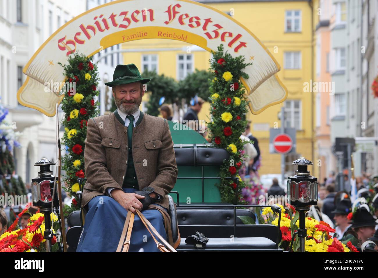 Une voiturette habitée par un homme dans une veste et un chapeau bavarois traditionnels au début de la parade de l'Oktoberfest. Banque D'Images
