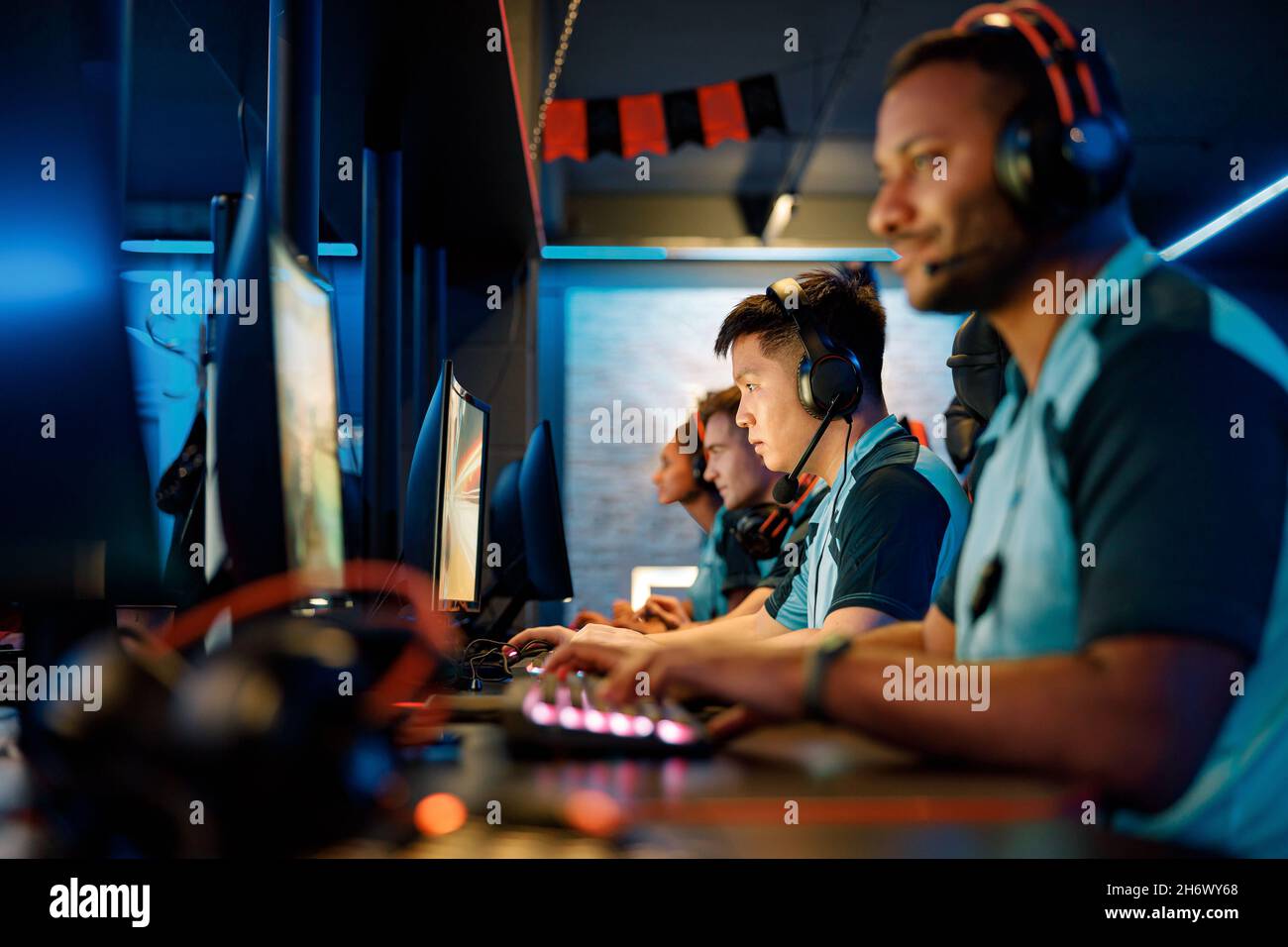 Équipe professionnelle jouant à un jeu vidéo multijoueur dans un cyber club Banque D'Images