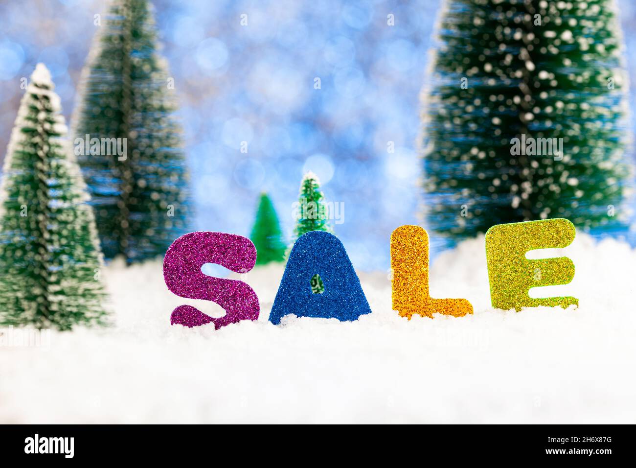 Soldes de Noël.L'inscription VENTE dans la neige sur fond de sapins verts dans la neige Banque D'Images