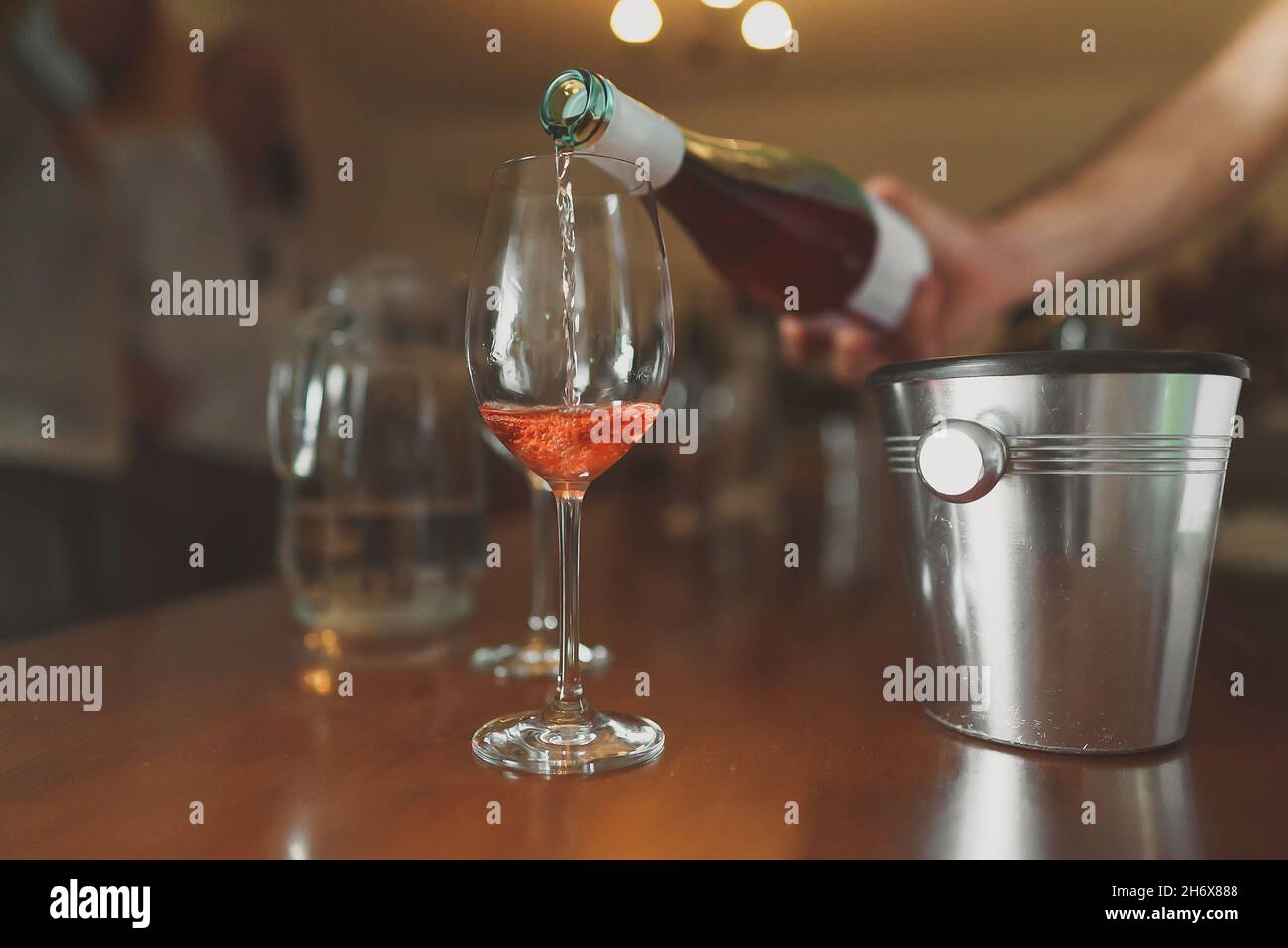 Le sommelier verse un verre de vin de rose pour une dégustation. Banque D'Images