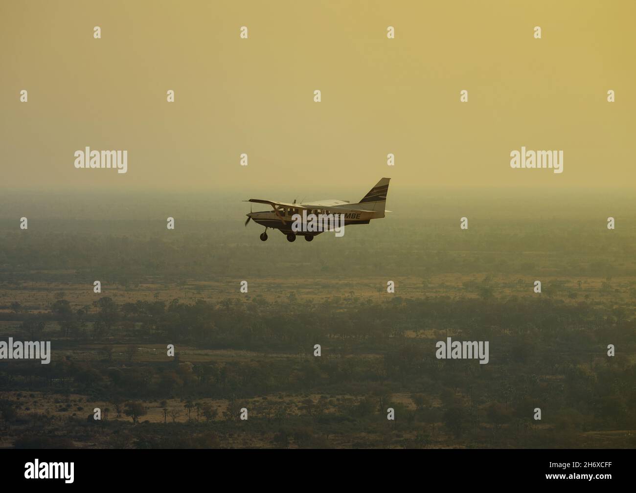 Avion léger avec touriste sur le vol panoramique au-dessus de l'Okavango au coucher du soleil Banque D'Images