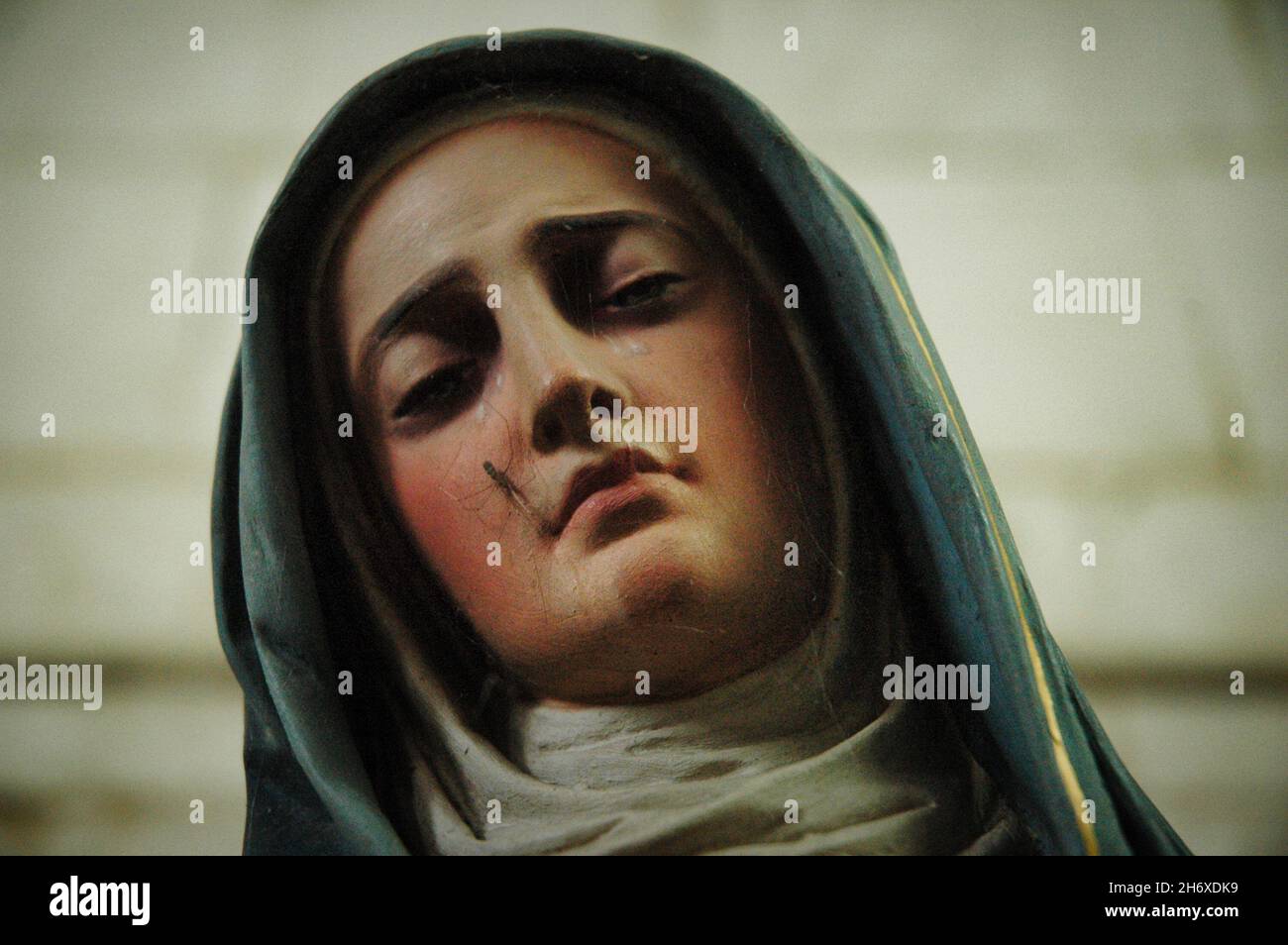 Statue en bois de Marie avec une araignée sur sa joue dans le nord de la France.Situation de lumière très atmosphérique. Banque D'Images