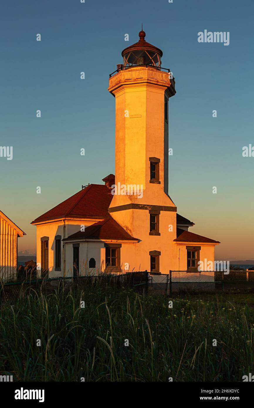 WA19797-00...WASHINGTON - coucher de soleil au phare de point Wilson dans le parc national de fort Worden. Banque D'Images