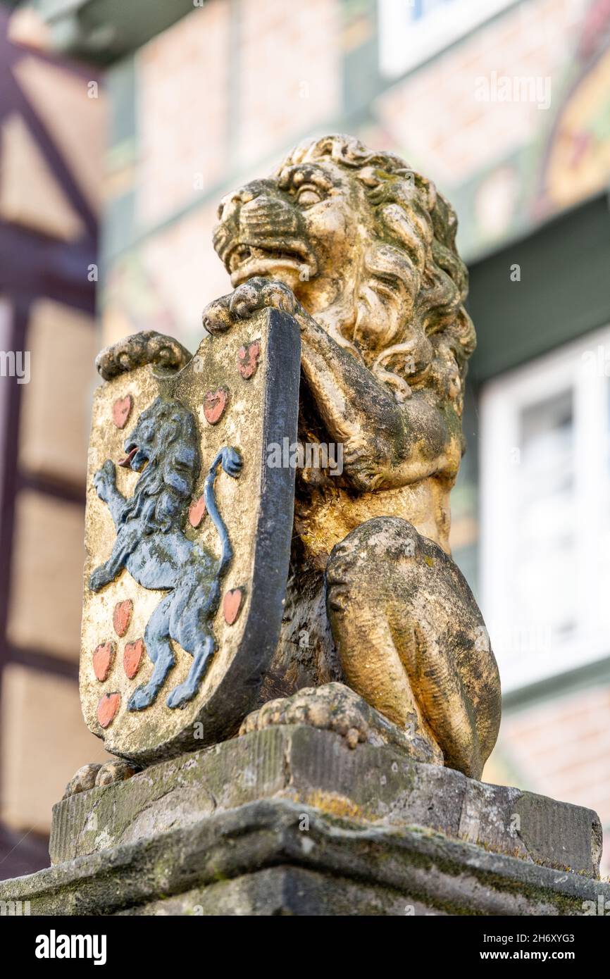 HOEXTER, ALLEMAGNE - 08 avril 2021 : un cliché vertical de sculpture de lion d'or tenant avec ses pattes un bouclier d'armes à Hoexter, Allemagne Banque D'Images