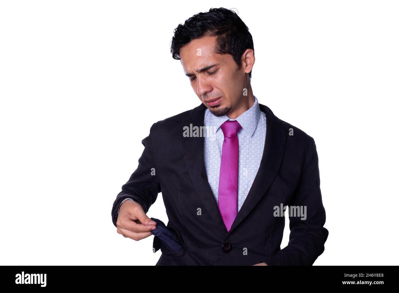 Homme d'affaires triste parce qu'il était à court d'argent.Jeune adulte latin jeune homme sortant de la poche vide de sa veste de costume, isolée sur tout fond blanc Banque D'Images