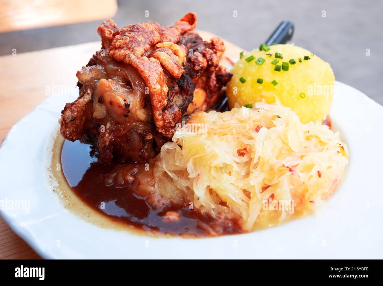 Schweinshaxe, cuisine bavaroise traditionnelle avec jarret de jambon rôti (jarret de porc) et boulettes de chou et de pomme de terre. Banque D'Images
