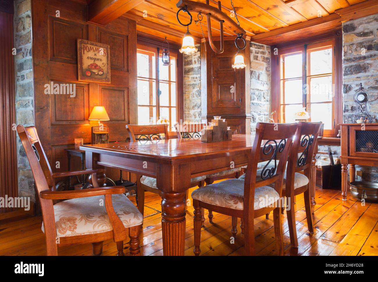 Table à manger en bois antique avec bois capitonné beige et chaises en acier forgé noir avec motifs dorés brodés dans la salle à manger de l'ancienne maison 1750 Banque D'Images