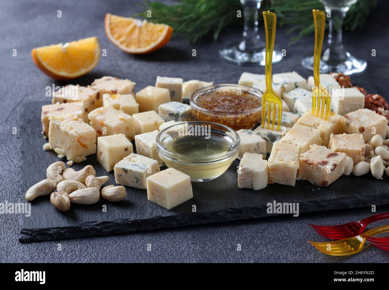 Assortiment de fromages d'élite sur un plateau d'ardoise sur fond sombre. En-cas pour une fête du vin. Banque D'Images