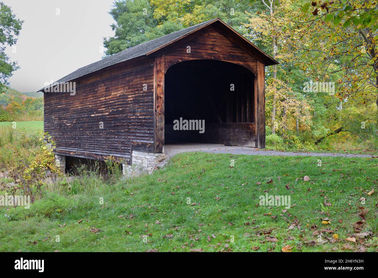 Cooperstown, New York, États-Unis.Vue du début de l'automne sur le pont couvert de Hyde Hall au-dessus de Shadow Brook.Le pont a été construit en 1825. Banque D'Images