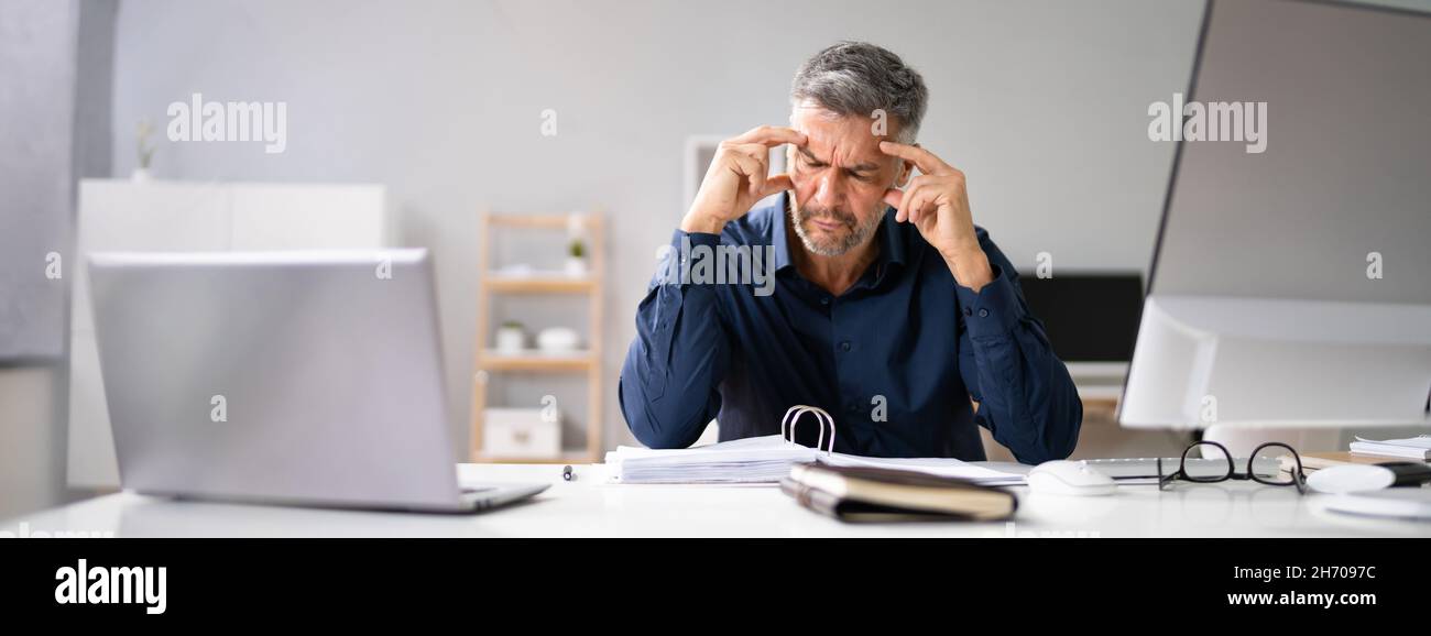 Comptable stressé homme avec mal de tête au bureau Banque D'Images