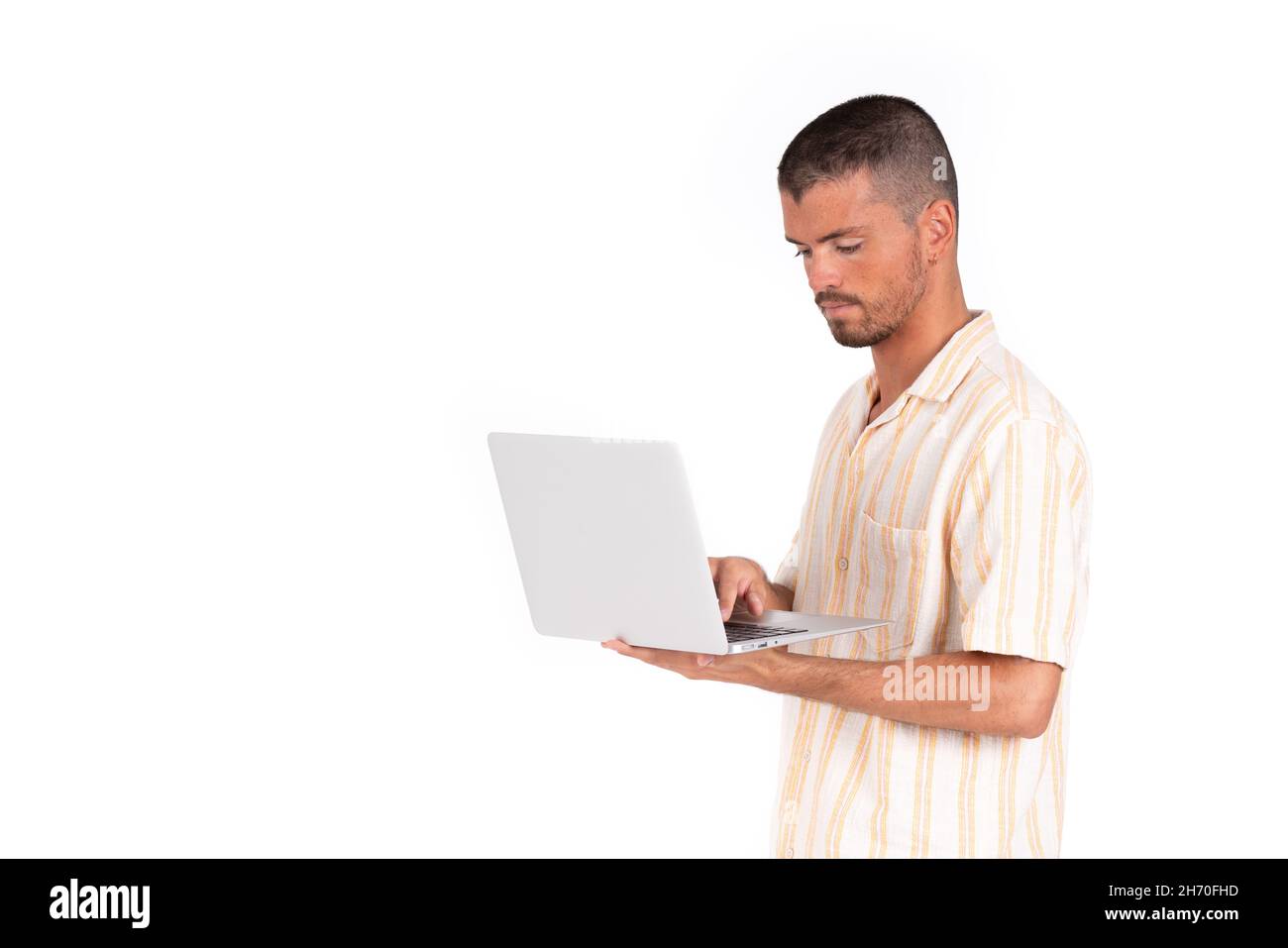 Jeune homme caucasien avec ordinateur portable gris sur fond blanc Banque D'Images