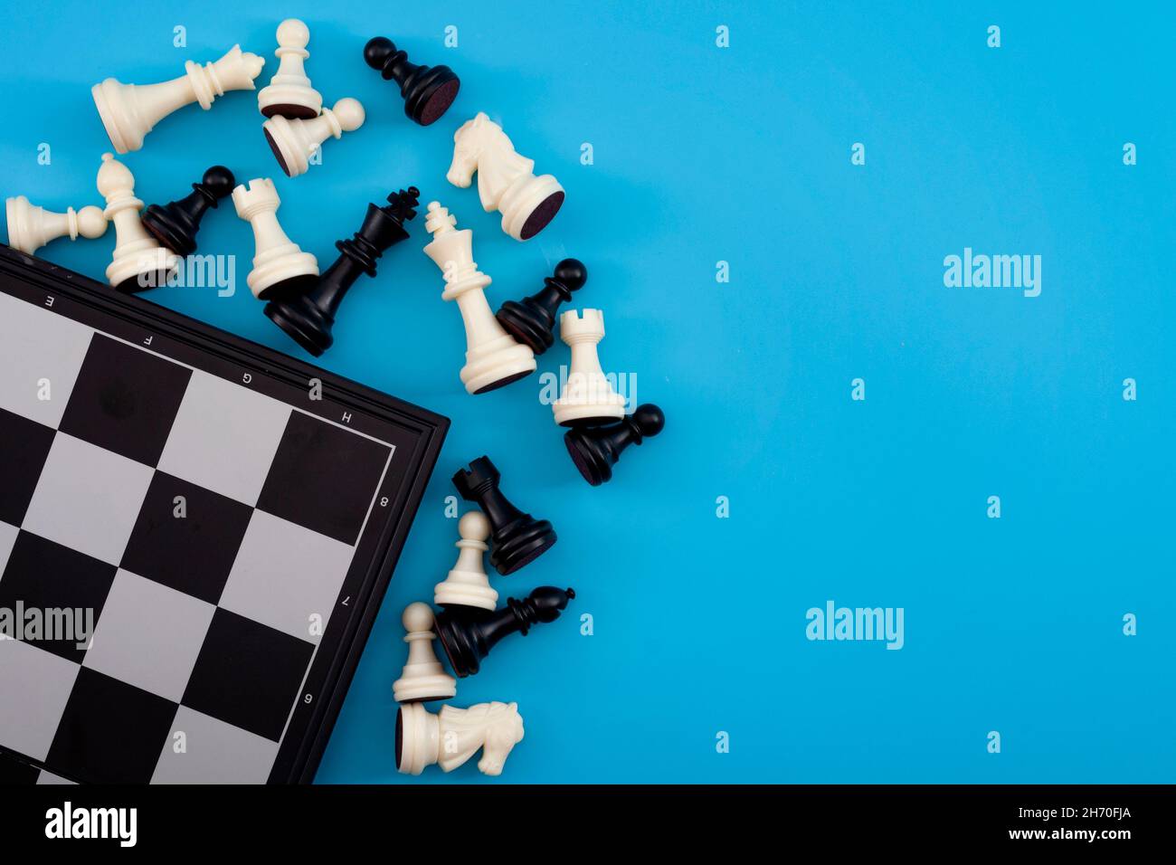 Pensée critique, tournoi d'échecs gagnant et concept de jeu d'esprit avec chessboard et figures isolées sur fond bleu avec espace de copie Banque D'Images