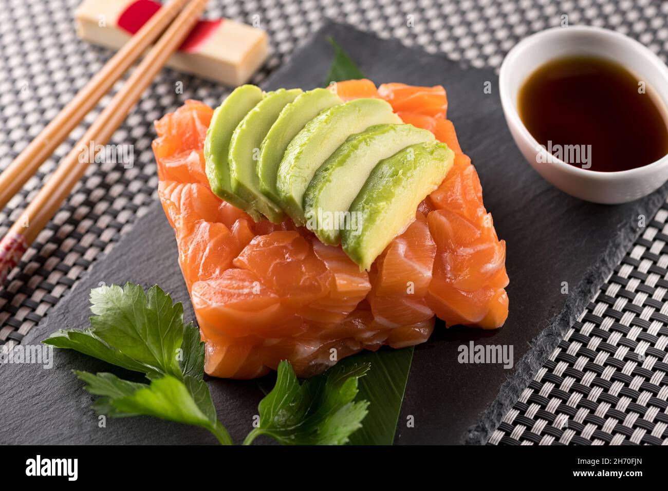 Sushi au tartare de saumon avec des tranches d'avocat, servi avec une