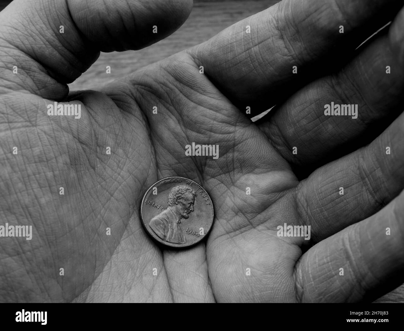 Gros plan de la pièce de monnaie d'un cent des États-Unis sur la main froissée Banque D'Images