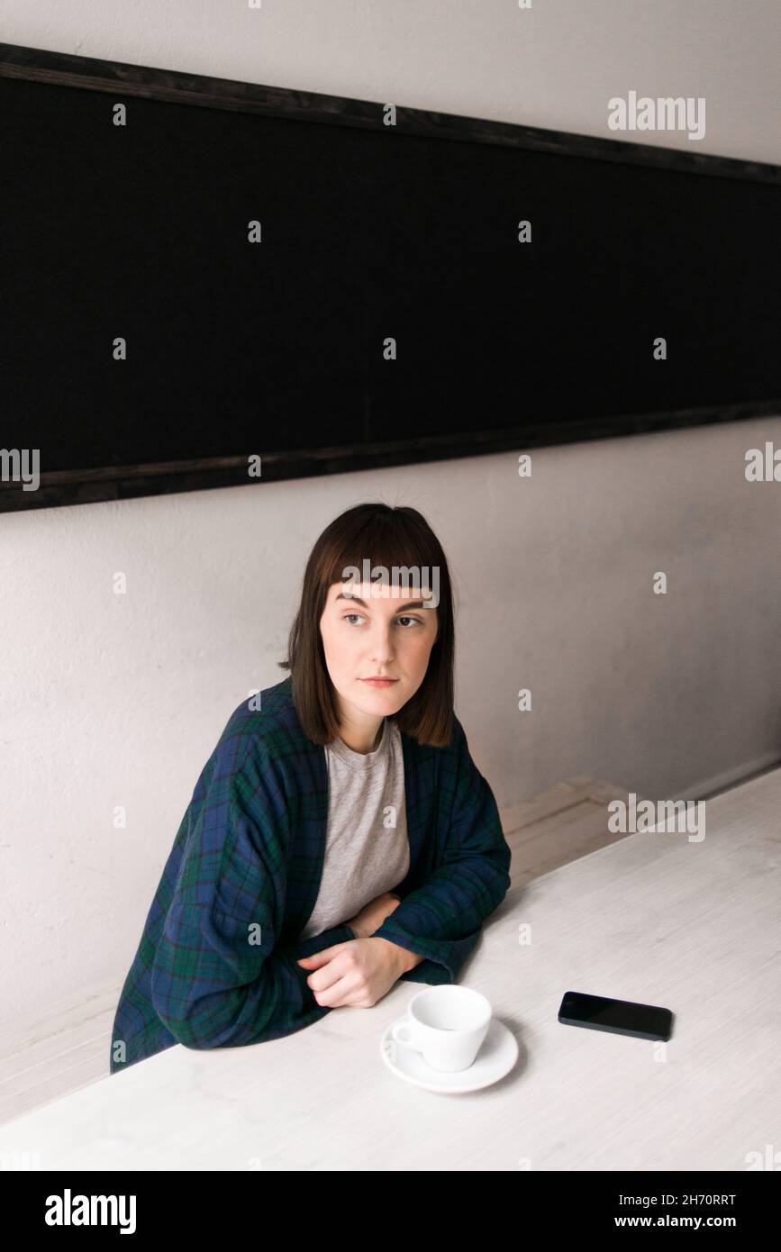 Young woman sitting at table Banque D'Images