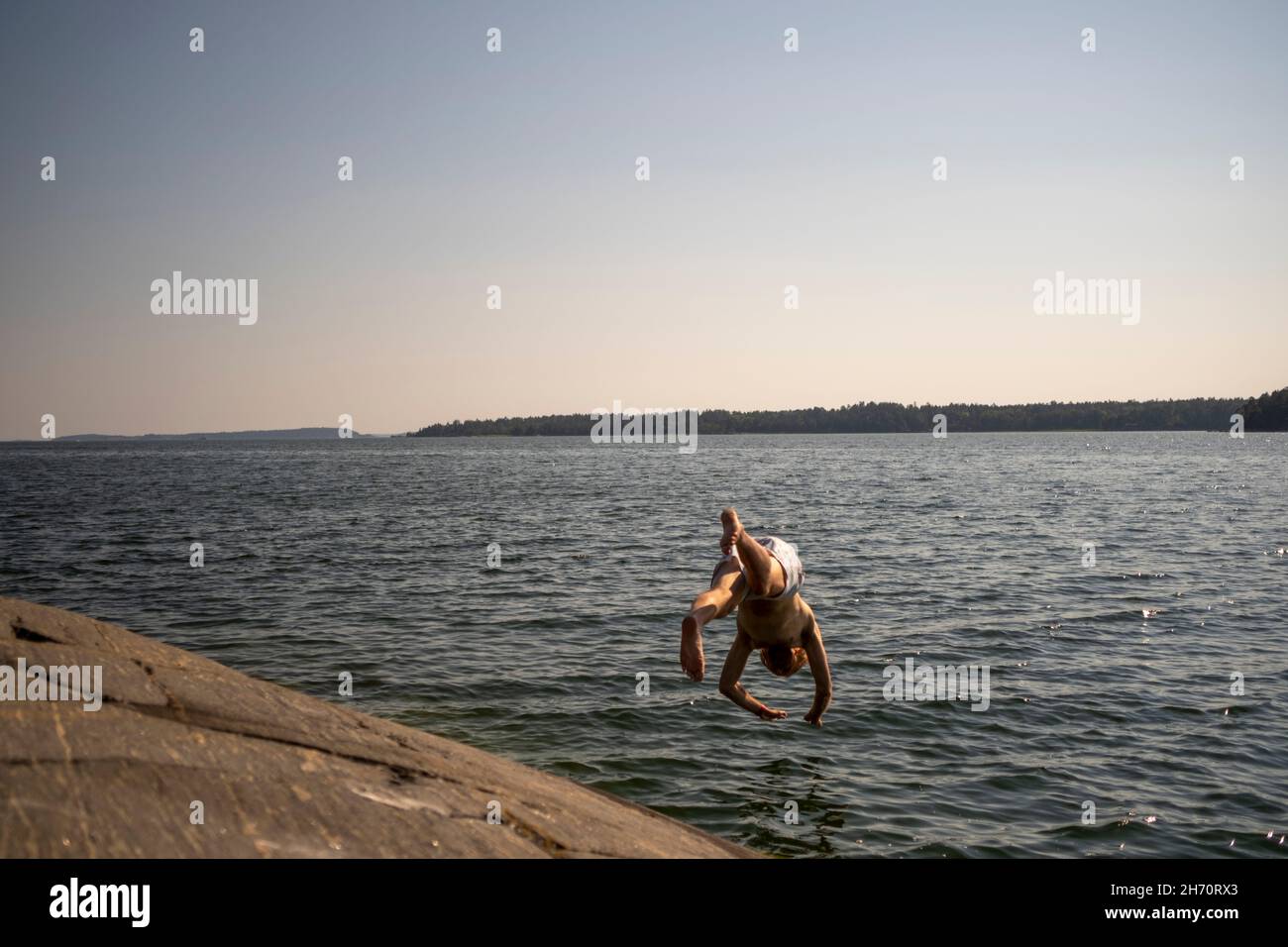 Garçon sautant dans l'eau Banque D'Images