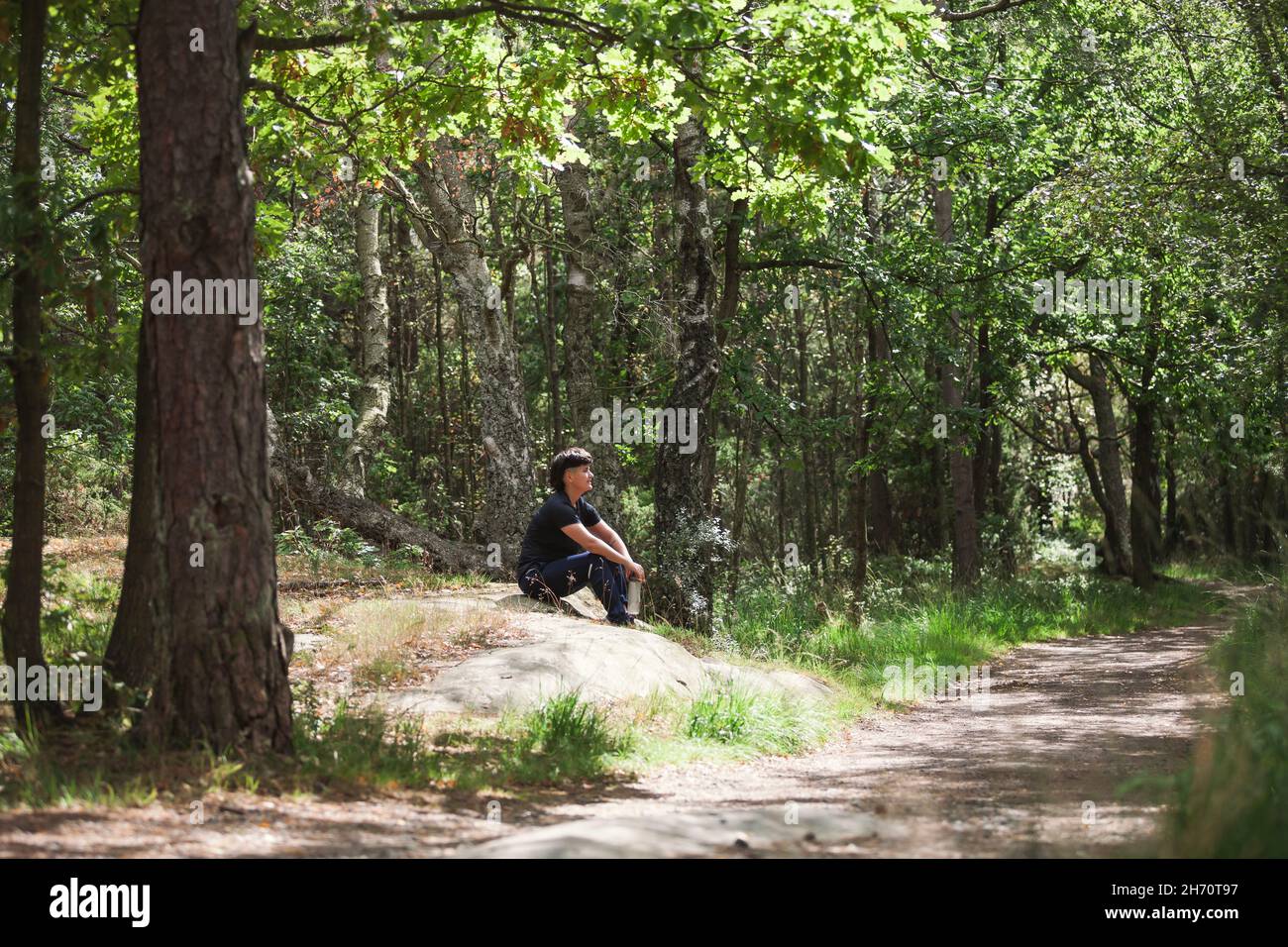 Jeune femme se reposant dans la forêt Banque D'Images