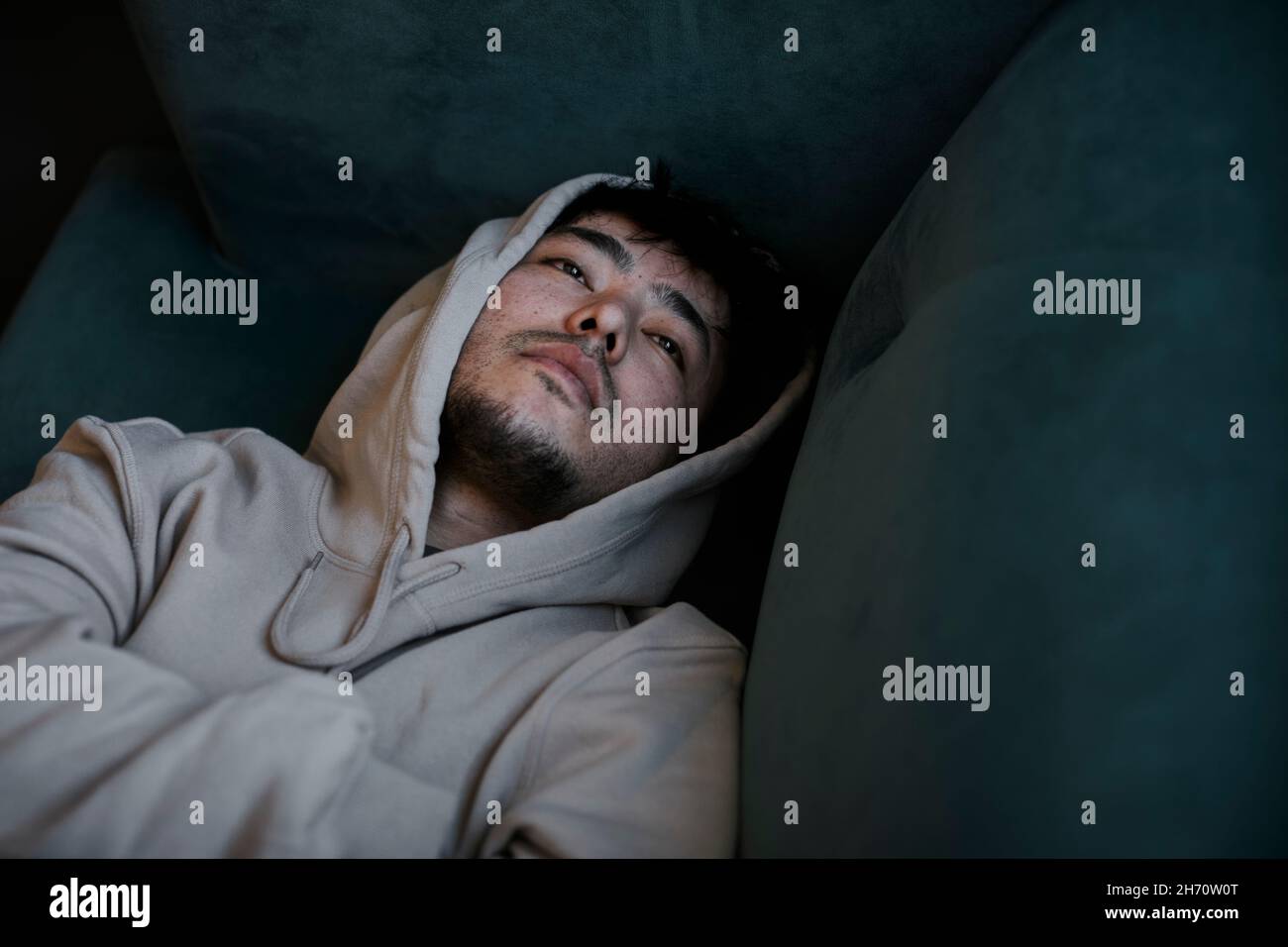 Vue en grand angle de l'homme allongé sur un canapé Banque D'Images