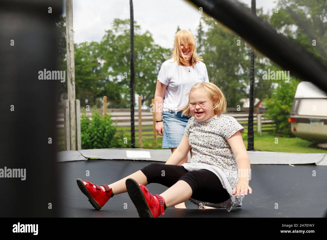Des filles souriantes jouant sur le trampoline Banque D'Images