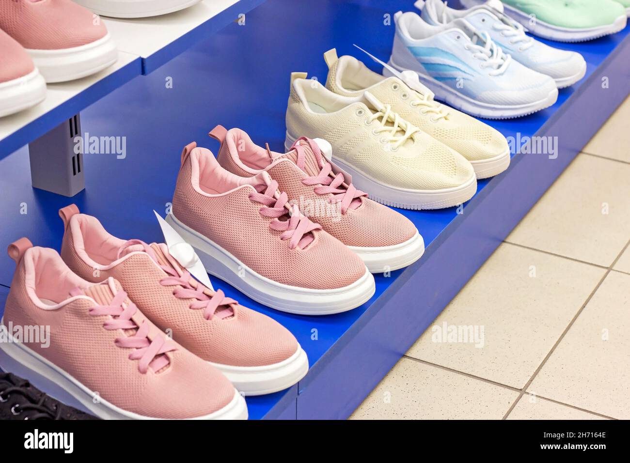 Nouvelles chaussures de sport sur l'étagère de présentation de la boutique de vêtements. Banque D'Images