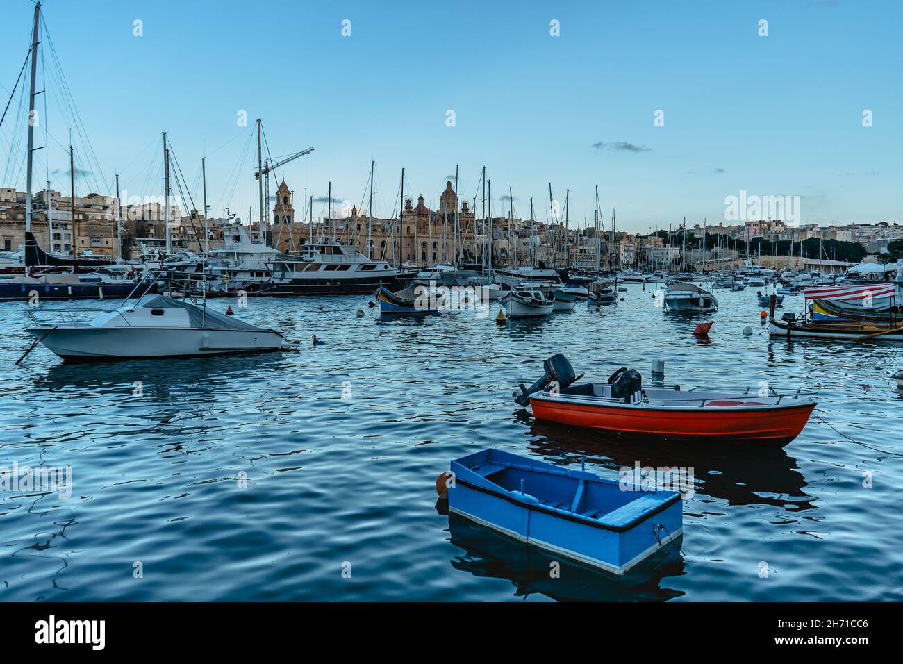 Traditionnel coloré Malte bateaux et yachts de luxe dans le port de Birgu au coucher du soleil, vieille ville en arrière-plan.Voyage concept de vacances.excursion en bateau en Méditerranée Banque D'Images