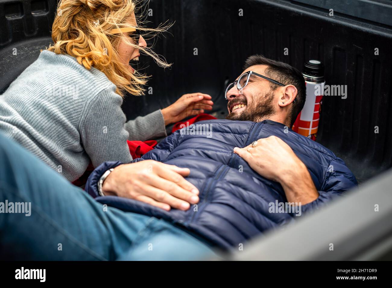 Adorable couple argentin gai allongé sur le lit de chargement d'une voiture de camion Banque D'Images