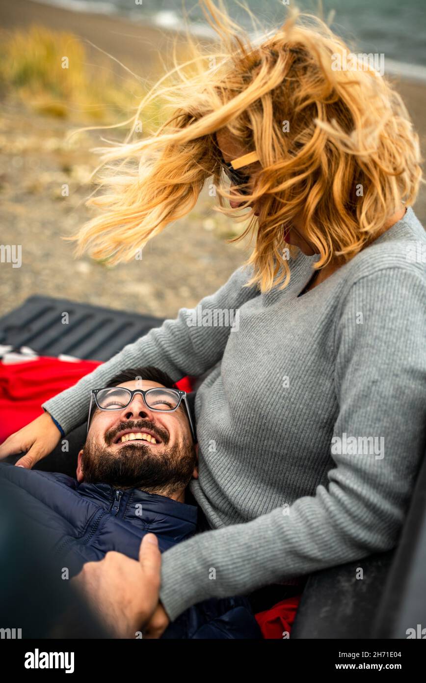 Adorable couple argentin adulte qui se coud à la plage par une journée venteuse Banque D'Images