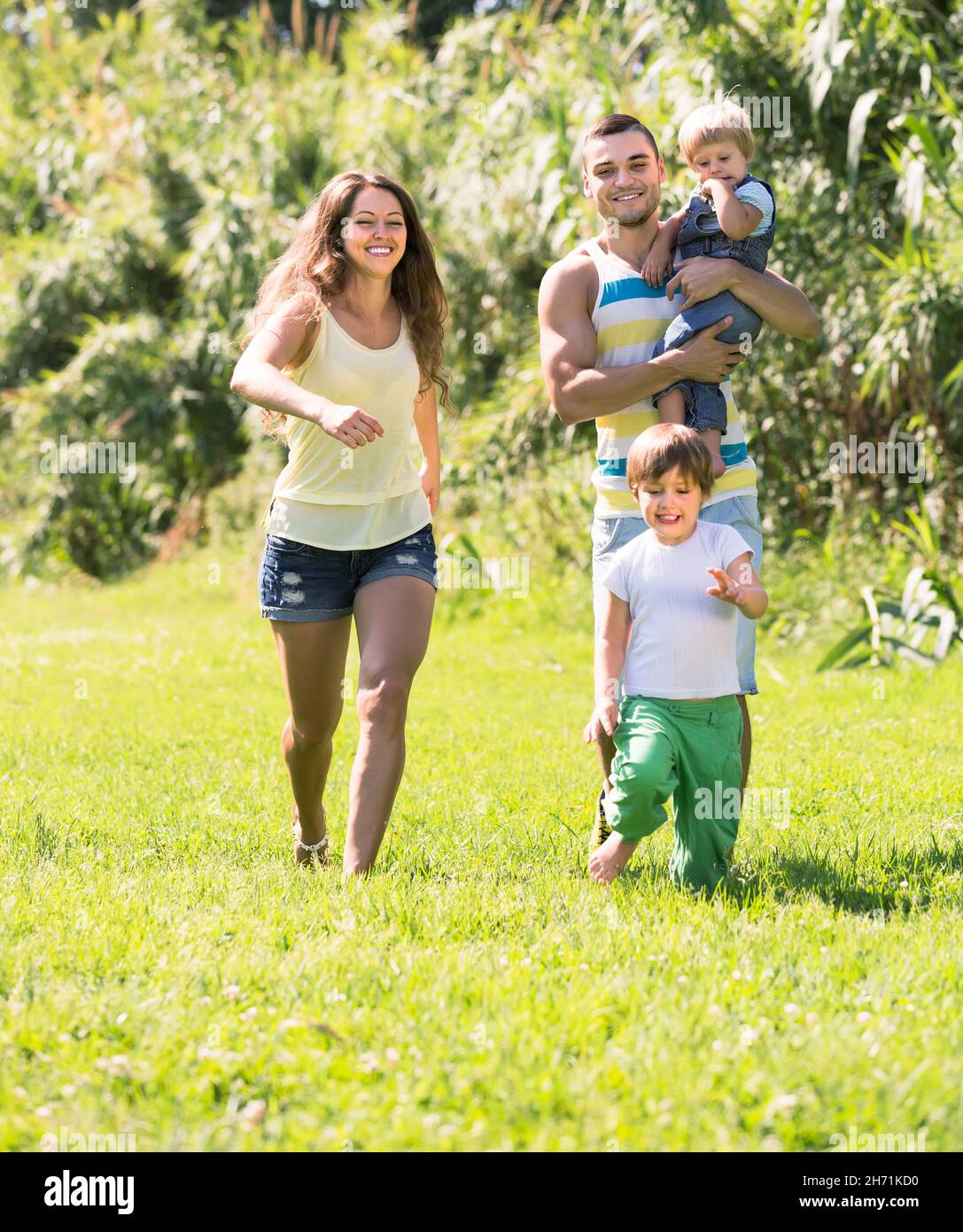 Famille de quatre personnes dans un parc ensoleillé Banque D'Images