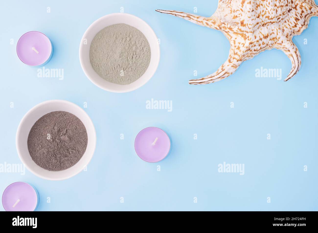 Argile cosmétique sur fond bleu, à côté d'une avec bougies, coquillages.Le concept des procédures cosmétiques de beauté, spa, traitement de la peau et soins de la peau.C Banque D'Images