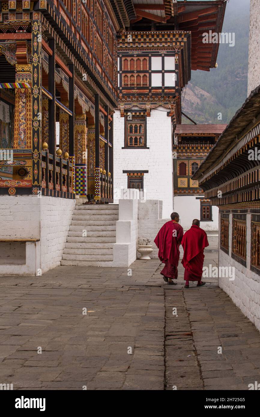 Deux moines bouddhistes marchant à l'intérieur du complexe Thimphu Dzong à Thimphu, au Bhoutan. Banque D'Images