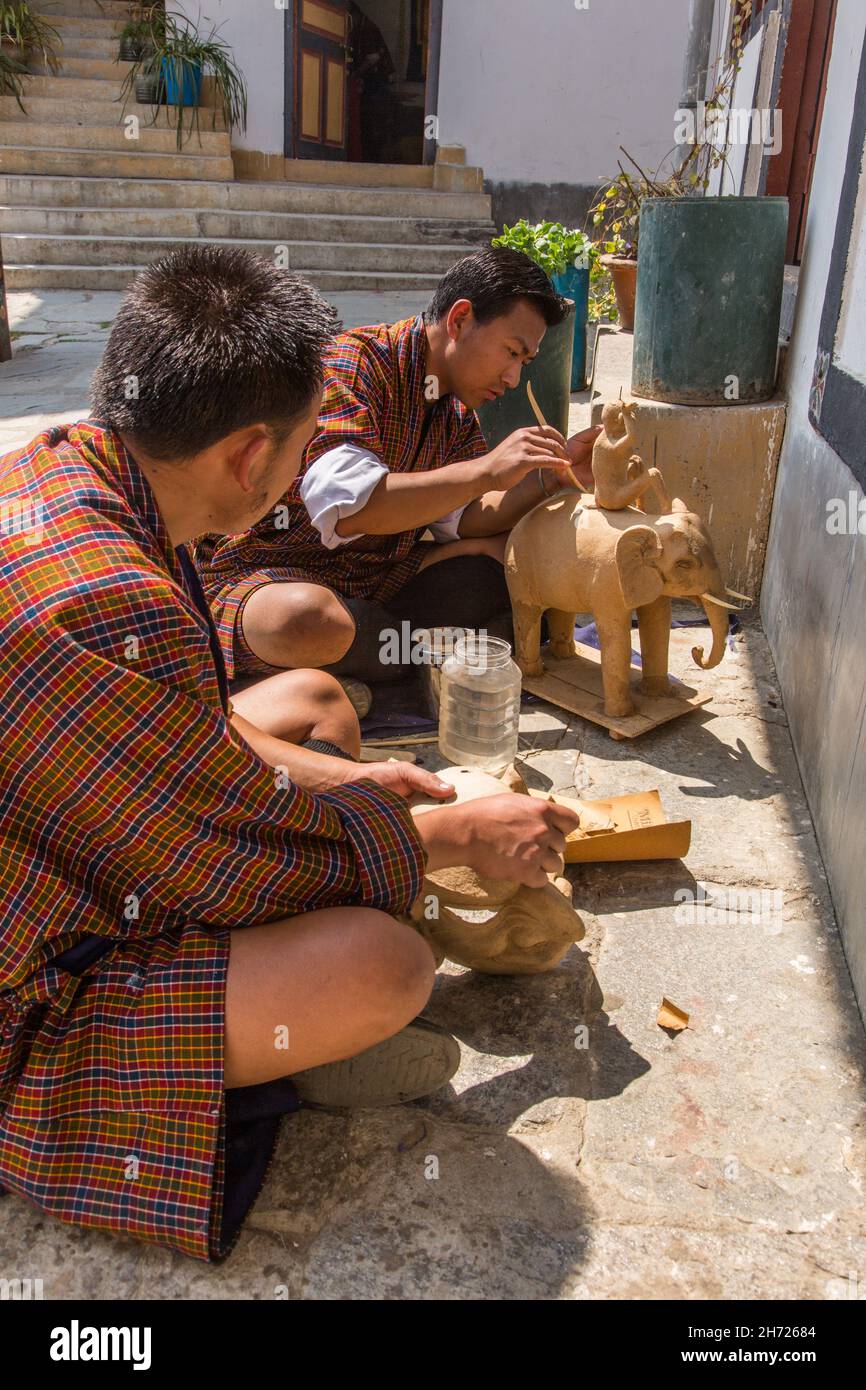 Deux jeunes hommes sculptant dans le bois à l'École nationale des arts de Thirsteen à Thimphu, au Bhoutan. Banque D'Images