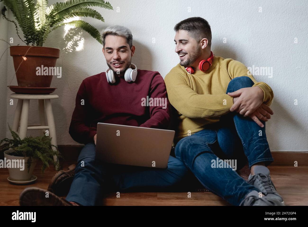Gay hommes couple s'amuser en utilisant l'ordinateur portable à la maison - Focus sur le visage masculin droit Banque D'Images