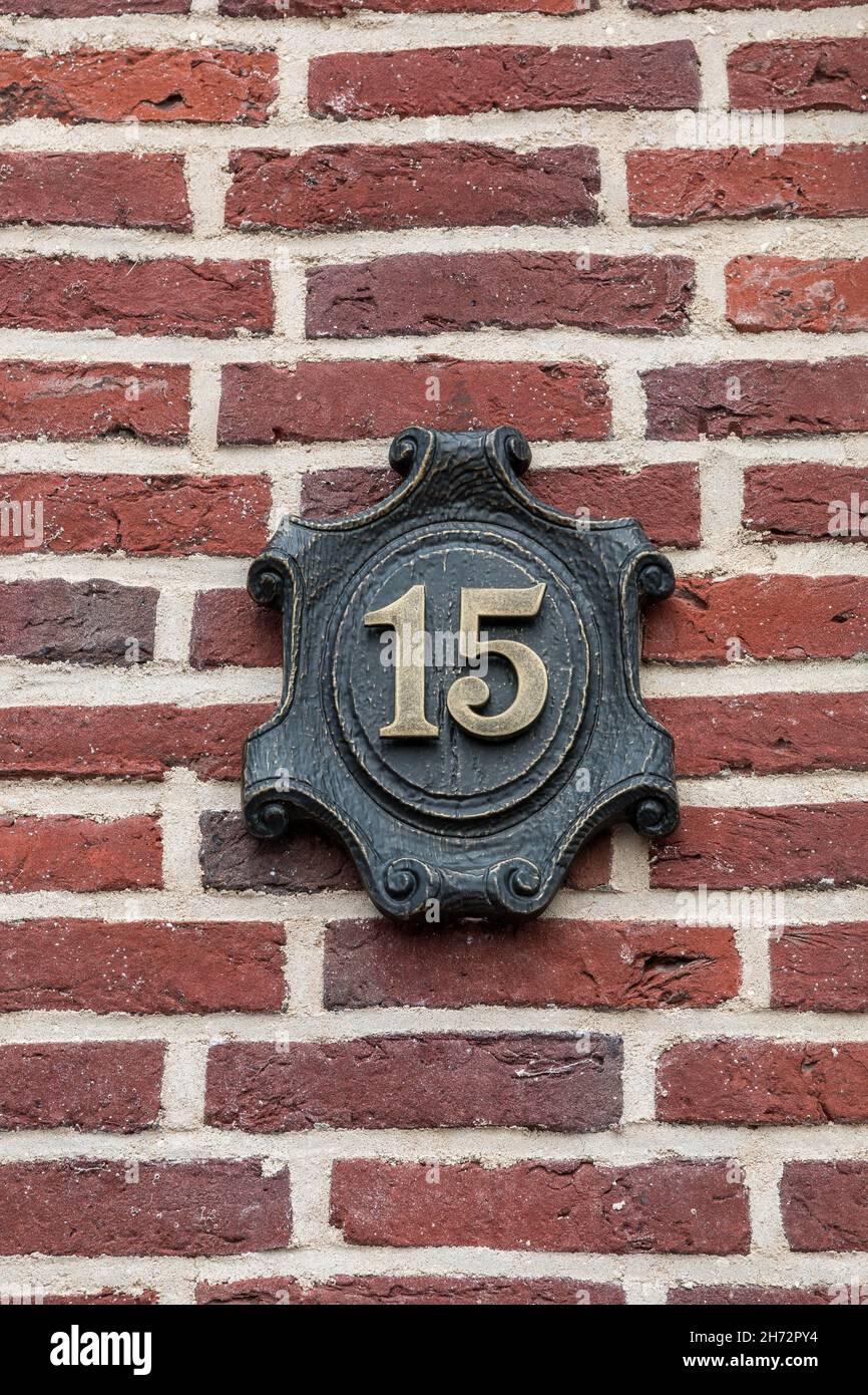 Numéro de maison en métal sur un mur de briques Banque D'Images