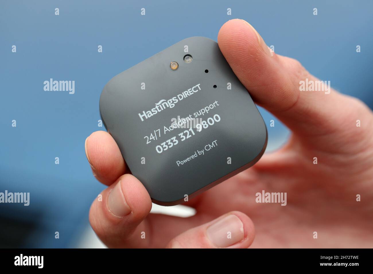 Un jeune conducteur sur le point d'installer une boîte noire télématique d'assurance automobile au Royaume-Uni dans sa nouvelle voiture. Banque D'Images