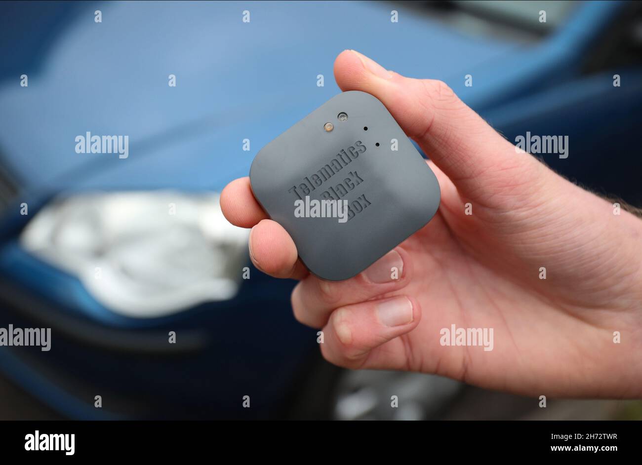 Un jeune conducteur sur le point d'installer une boîte noire télématique d'assurance automobile au Royaume-Uni dans sa nouvelle voiture. Banque D'Images