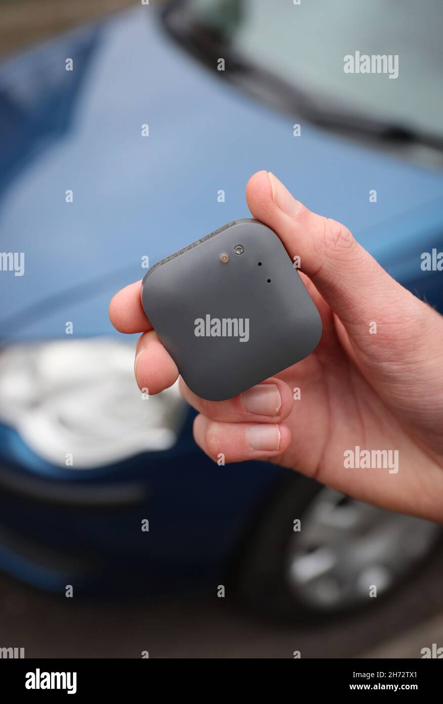Un jeune conducteur sur le point d'installer une boîte noire télématique d'assurance automobile au Royaume-Uni dans sa nouvelle voiture. Banque D'Images
