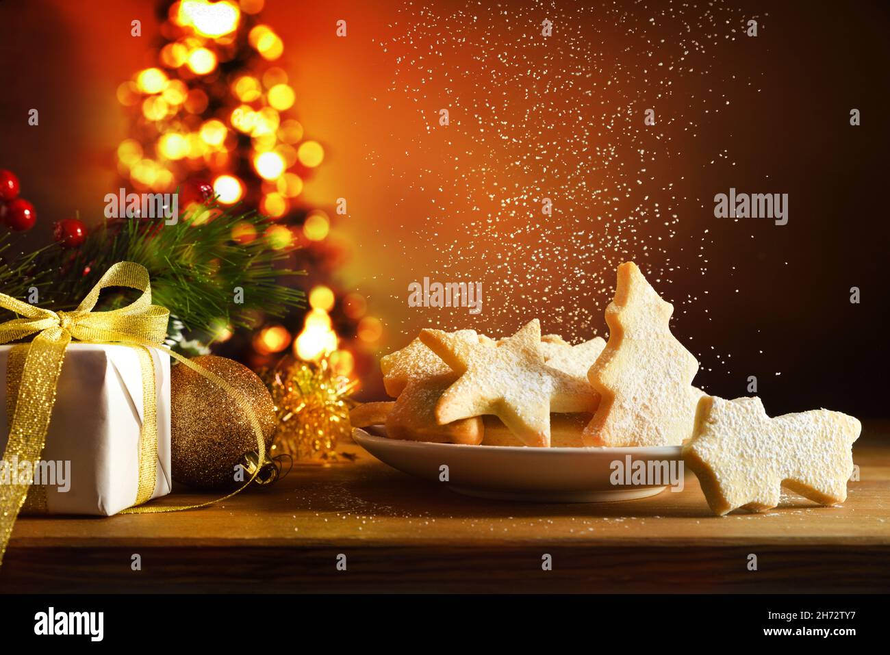 Table en bois avec biscuits aux formes de Noël fraîchement préparées sur l'assiette avec décoration de Noël isolé fond blanc.Vue avant.Horizontale Banque D'Images