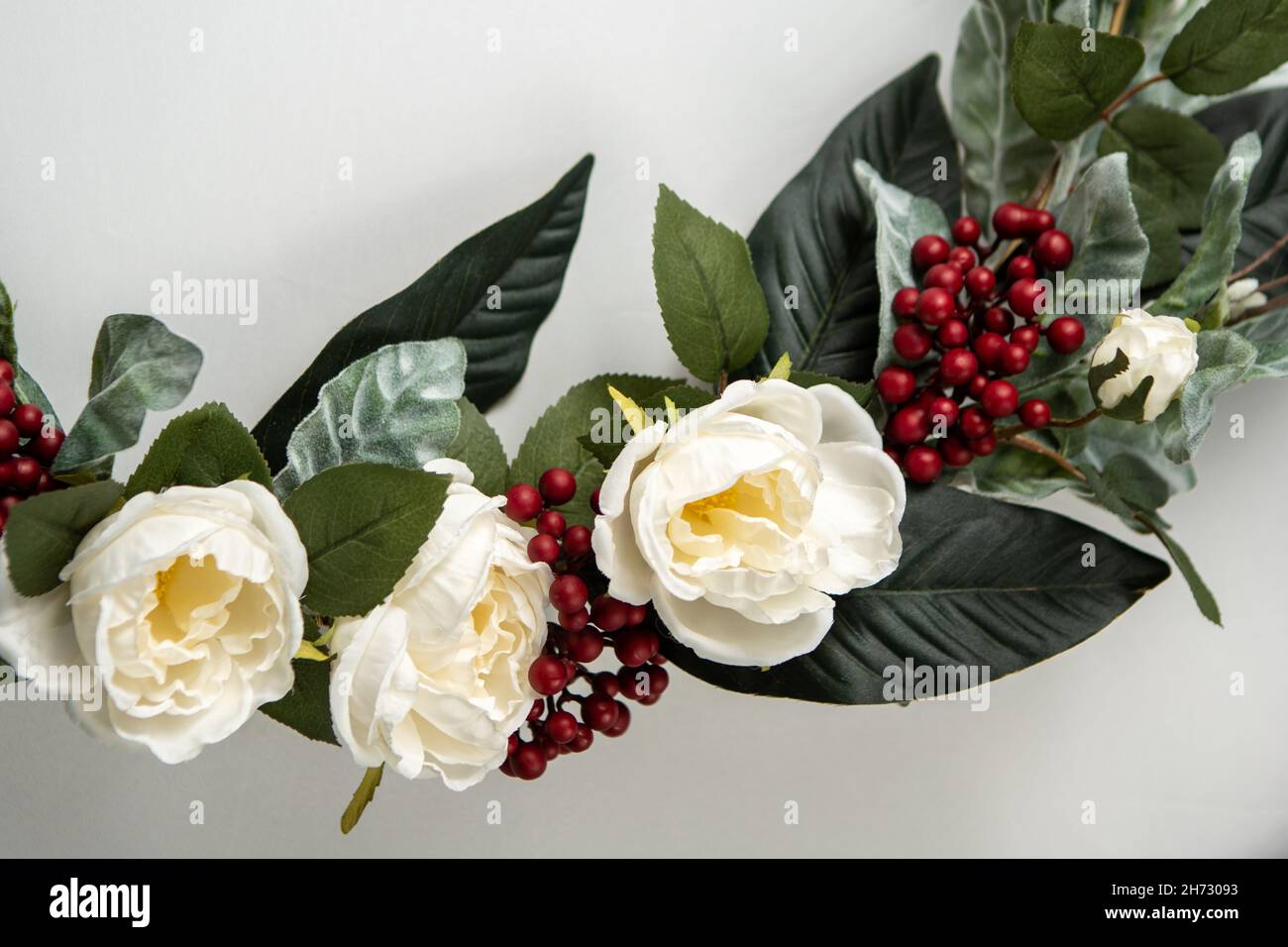 Gros plan de fleurs et de canneberges sur la couronne de Noël Banque D'Images