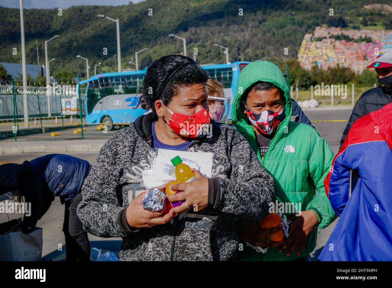 Le 18 juillet 2020, les familles de migrants vénézuéliennes qui vivent dans le centre de transport du nord de Bogota, en Colombie, reçoivent des aides alimentaires dans le cadre des lockdossements sectorés de la pandémie COVID-19. Banque D'Images