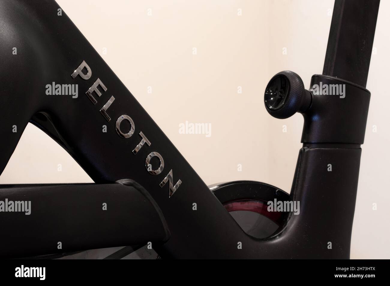 Un logo en forme de Peloton chromé sur le corps principal du tout nouveau Peloton Bike+, un vélo d'exercice populaire. Banque D'Images