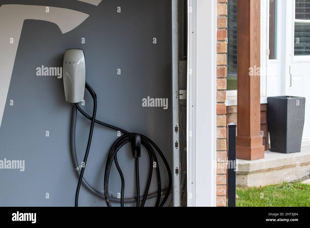 Un chargeur domestique Tesla installé dans le garage du propriétaire d'une voiture pour son véhicule électrique Tesla. Banque D'Images Un chargeur domestique Tesla installé dans le garage du propriétaire d'une voiture pour son véhicule électrique Tesla. Banque D'Images