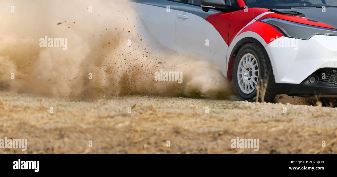 La voiture de course de rallye glisse sur la piste de terre. Banque D'Images