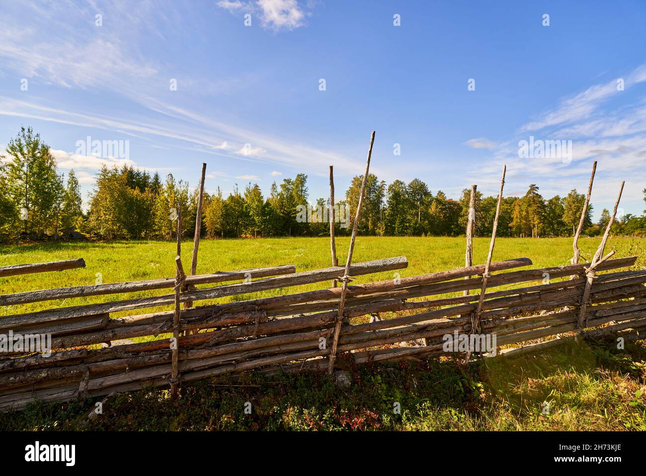 Ancienne clôture en bois suédoise traditionnelle.Haie de style vintage.Campagne authentique palisade de clôture en bois faite à la main dans une zone rurale. Banque D'Images